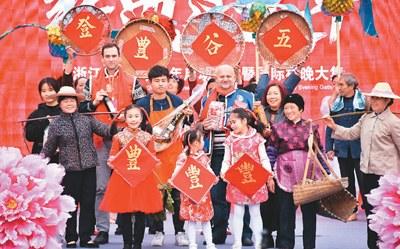中国侨网国际友人与青田本地村民共同参演国际村晚节目《丰收的记忆》(《人民日报海外版》/黄玲晓文 张永益摄)