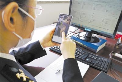 中国侨网海关工作人员利用视频监控系统进行生产物资远程查验。