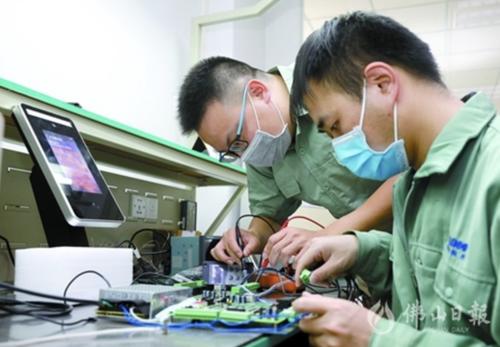 中国侨网伟邦科技公司研发人员正在测试红外线体温检测系统。(佛山日报记者龙翔摄)