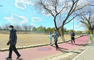 中国侨网3月2日，在奥森公园，人们戴着口罩，保持距离，散步、晒太阳、跑步。本报记者 刘平摄 