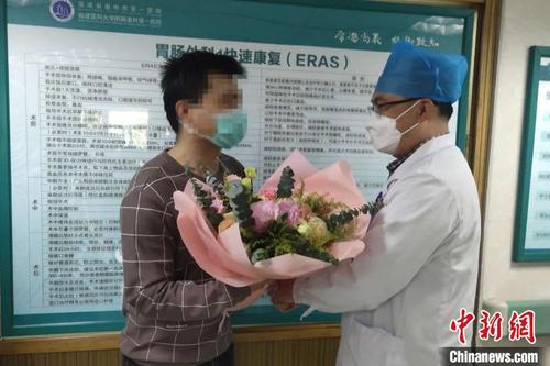 中国侨网3月10日，福建泉州欣佳酒店坍塌事故中获救的10名轻伤者出院。图为出院的王先生从医护人员手中接过花束。　全轩　摄