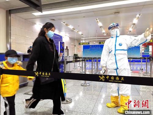 中国侨网图为济南机场海关工作人员对进境旅客进行引导。　董海东　摄