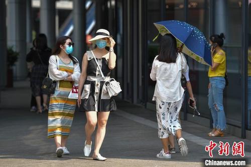 中国侨网图为海口市民众在高温下出行。　骆云飞　摄