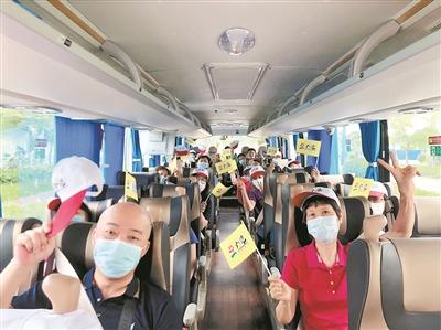 中国侨网参加首团的市民在车内间隔落座，非常高兴。