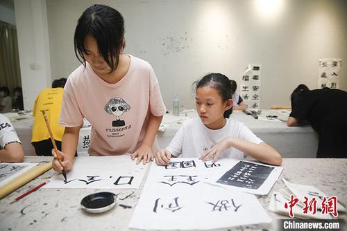 中国侨网图为6月13日,年轻人在水藤村红基石党群服务中心内学习书法。 中新社记者 王骏 摄