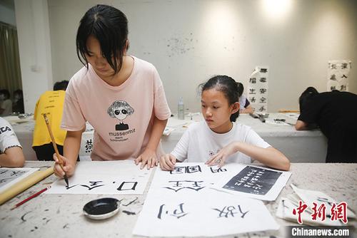 中国侨网图为6月13日，年轻人在水藤村红基石党群服务中心内学习书法。 中新社记者 王骏 摄