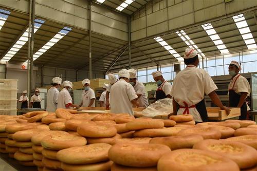 中国侨网7月7日，工人在新疆喀什地区伽师县馕产业园制作馕。（新华社/高晗 摄）