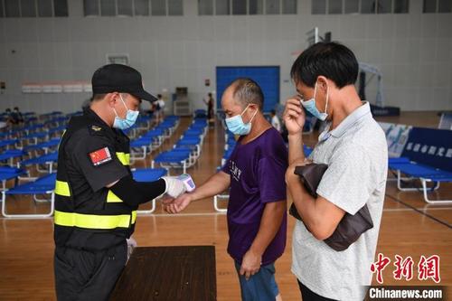 中国侨网温州乐清一安置点工作人员正在对转移人员进行测温。 王刚 摄