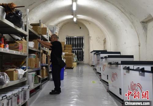 中国侨网图为火锅店老板在防空洞改造的库房里整理货物。 周毅 摄