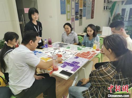 中国侨网在福州市台湾青年创业就业服务中心里，台湾桃园青年简以信和福州的青年创业者们体验桌游“创业版大富翁”。　陈思畅　摄
