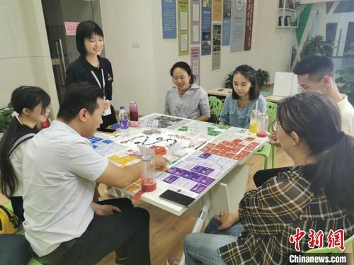 中国侨网在福州市台湾青年创业就业服务中心里,台湾桃园青年简以信和福州的青年创业者们体验桌游“创业版大富翁”。 陈思畅 摄
