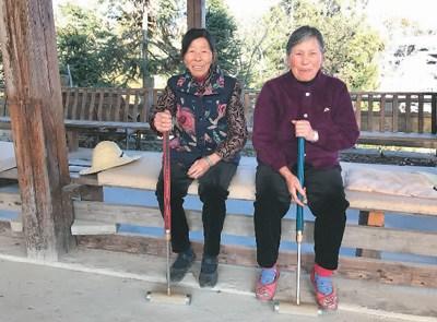 中国侨网图为郭新美(左)与球友打球间隙,在球场边休息。