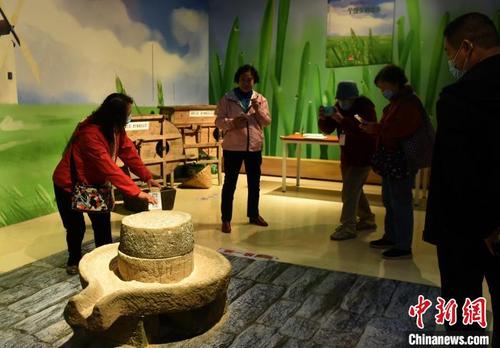 中国侨网图为市民体验农具，回忆儿时农耕生活。　周毅　摄