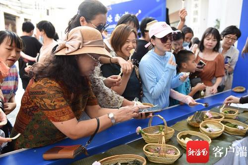 中国侨网　　市民游客在海口骑楼老街品尝南洋风味美食。