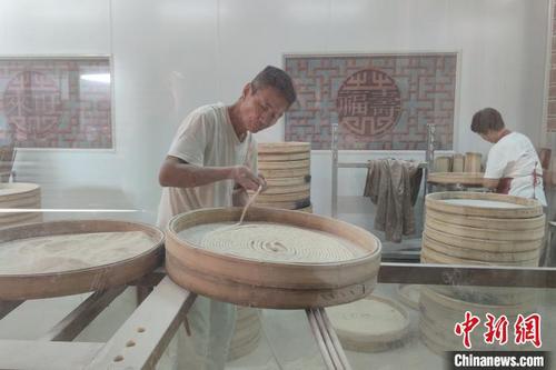 中国侨网在来旺良品堂闽南古早味传承基地，游客透过透明的橱窗，可以观看手工面线等美食的制作流程。　吴冠标　摄