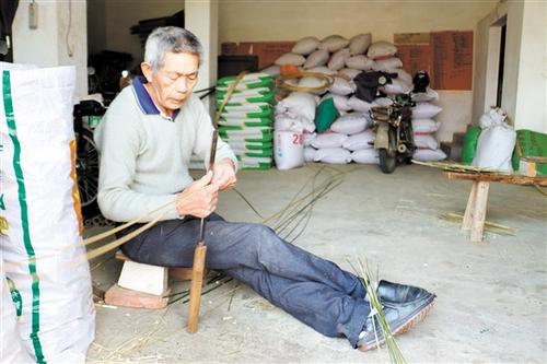 中国侨网麦树林利用闲暇时间编织竹篮。