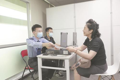 中国侨网出入境民警在指导台胞填报台胞证换领材料。