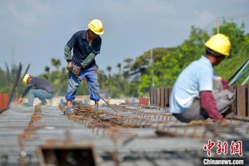 中国侨网图为在国道G360文临公路文昌段项目施工现场,工人在烈日下施工。 骆云飞 摄