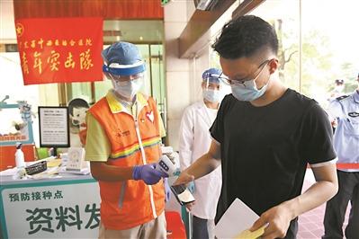 中国侨网胡伟雄（左）在广东省中西医结合医院进行志愿服务。（全媒体记者 陈枫）