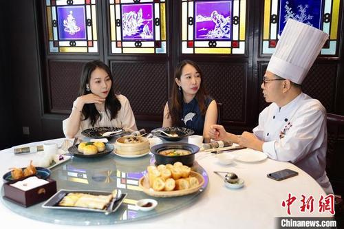 中国侨网白天鹅宾馆点心厨房大厨谭广燐在玉堂春暖餐厅进行直播。 严筱薇 摄