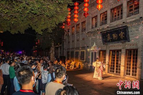 中国侨网图为中外嘉宾在福州三坊七巷观看演出。　闽分　摄