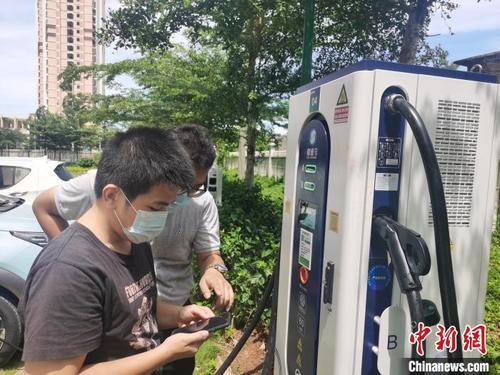 中国侨网海口一小区电动汽车车主在研究充电桩。　黄艺　摄