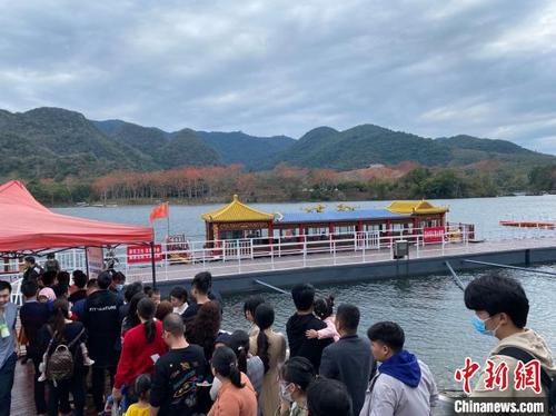 中国侨网海南昌化江畔木棉赏花码头,游客排队乘船漫游赏木棉。 符宇群 摄