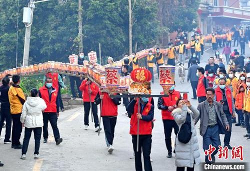 中国侨网民众抬起长长的板凳龙灯穿梭在村道上闹元宵。林弘梫　摄