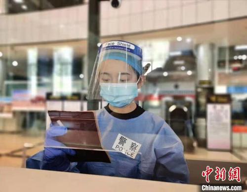 中国侨网图为民警核对证件。 磨憨边检站供图