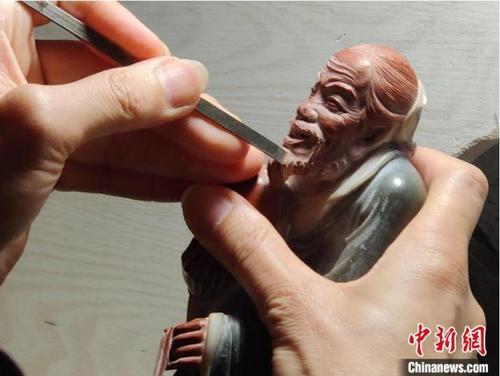 中国侨网 寿山石雕刻大师林国仲正在雕刻作品。　叶秋云　摄