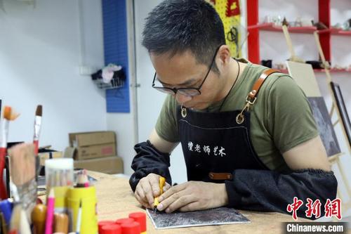 中国侨网福州马尾版画艺术家,非物质文化遗产传承人檀俊灶用手中的雕刻刀创作《防疫——全民核酸》系列版画作品。 陈晓静 摄
