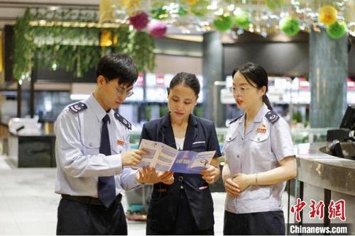 中国侨网图为佛山税务人员向餐饮企业介绍社保费缓缴政策 张健聪 摄