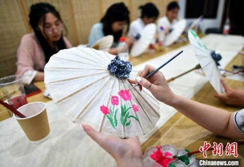 中国侨网7月3日,2022年两岸青年中华文化(闽都文化)研学体验营探访烟台山,学做油纸伞。 张斌 摄