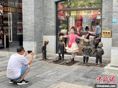 中国侨网图为游客在前门大街拍照。　徐婧　摄