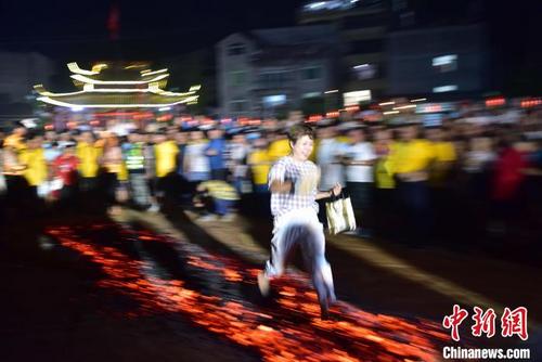 中国侨网8月14日,游客勇敢穿过经盐等处理过的炭火(勿模仿)。代表红红火火。 张丽君 摄