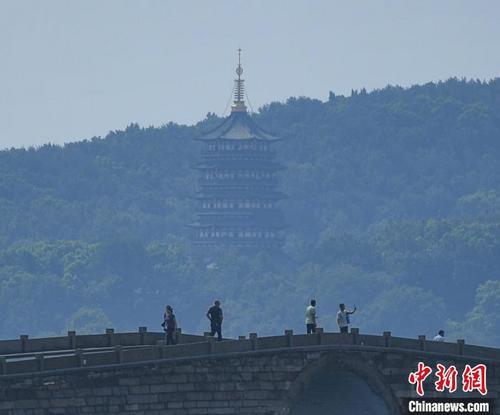 中国侨网图为：游客在西湖锦带桥游览。　王刚　摄