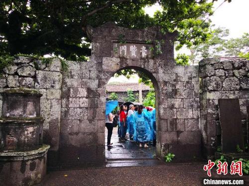 中国侨网图为中国传统村落海口市三卿村,游人参观三卿村“豪贤门”。 尹海明 摄