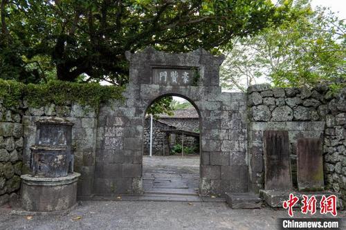 中国侨网三卿村古雅的“豪贤门”,建于光绪年间,是用当地的火山岩石堆垒而成,左侧有一个敬字亭,右侧有两块古碑。 凌楠 摄
