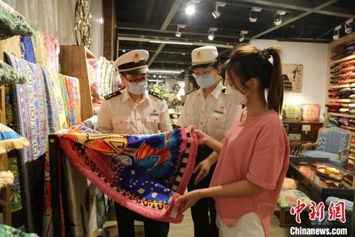 中国侨网广州海关所属荔湾海关关员在调研市场采购贸易出口服饰商品情况。 关悦 摄
