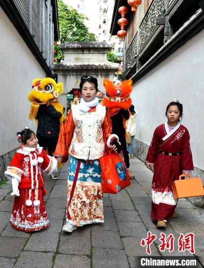 中国侨网“迎财神”队伍在福州三坊七巷巡游送祝福。　吕明　摄