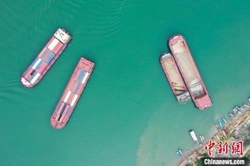 中国侨网图为江面上等待装卸货物的船舶。　王伟臣　摄