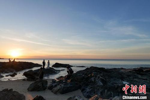 中国侨网7月23日，新人在海南文昌木兰湾海边拍摄婚纱
