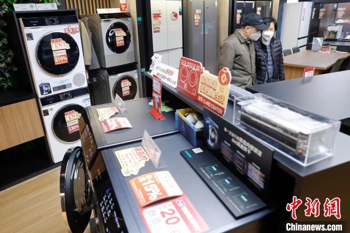 中国侨网2月4日，市民在京东电器城市旗舰店长宁路店了解洗衣机相关信息。1月28日，上海市商务委员会发布2025年加力支持家电家居家装消费品补贴的具体方案，自1月29日起至12月31日，上海将对7类产品（家电类、装修建材类、卫生洁具类、家具照明类、智能家居类、居家适老化类、家纺类）进行补贴，补贴额度从15%到30%不等。中新社记者 殷立勤 摄