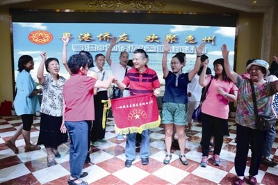 中国侨网巡回年会会旗交到赖志平手中，深圳侨友欢呼雀跃。