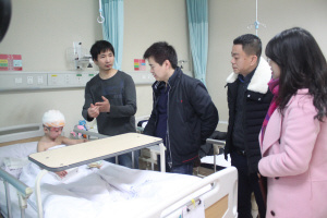 中国侨网图为林小军、陈志荣在小高鑫的病床前了解治疗情况。