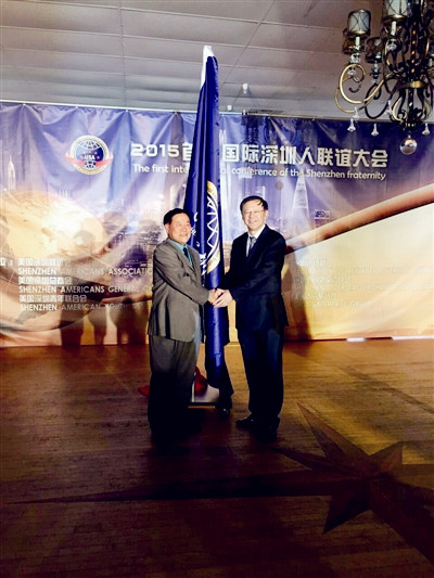 马勇智(右)为首届国际深圳人联谊大会授旗。