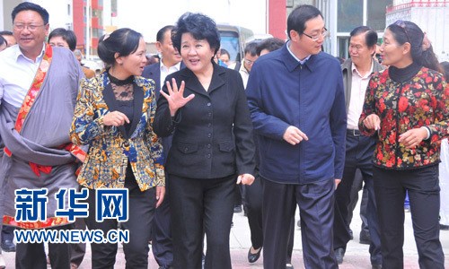 国侨办主任裘援平(左三)步入青海玉树第三完全小学校门,听取工作人员介绍情况。(新华网/张敏彦