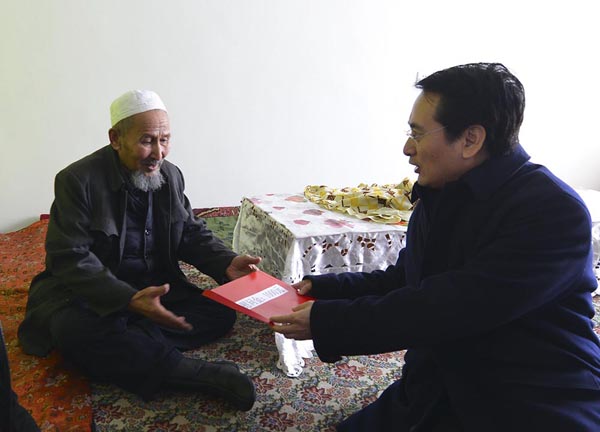 中国侨网1月6日,国务院侨办副主任谭天星(右)一行,来到新疆奇台县华侨村归国华侨、76岁的克里木·艾莎老人家中,与老人坐在炕头拉家常。据了解,克里木·艾莎老人6岁时回到国内,已在华侨村居住了70年。 刘新 摄