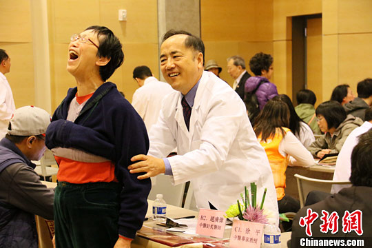 当地时间10月15日,一名中医师为侨胞治疗。中新社记者