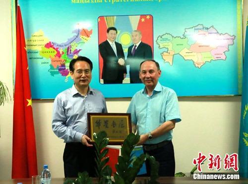 中国侨网8月10日，中国国务院侨办副主任谭天星（左）走访阿拉木图市哈中国际语言学院，并向该学校赠送“华星书屋”牌匾。